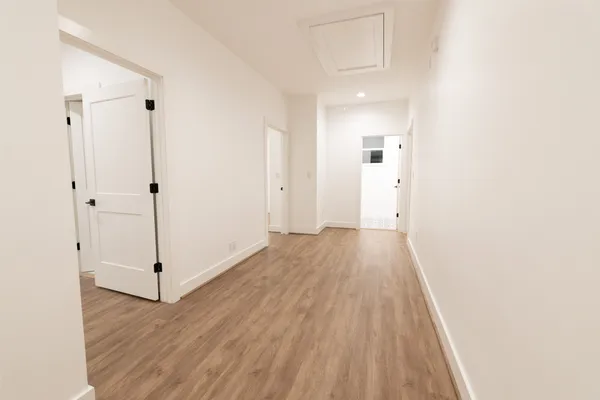 a view of a hallway with wooden floor