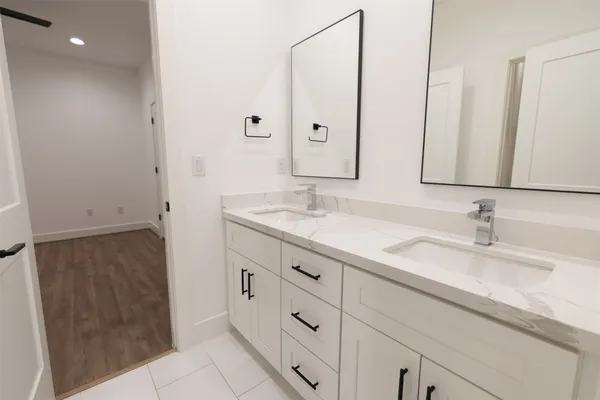 a bathroom with double sink and a mirror
