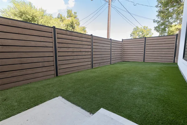 a view of a backyard with wooden fence