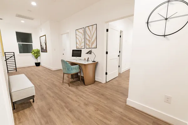 a living room with furniture a table and wooden floor
