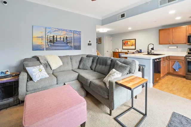 a living room with furniture and a kitchen view