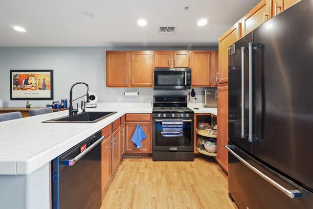 a kitchen with stainless steel appliances a refrigerator sink and stove