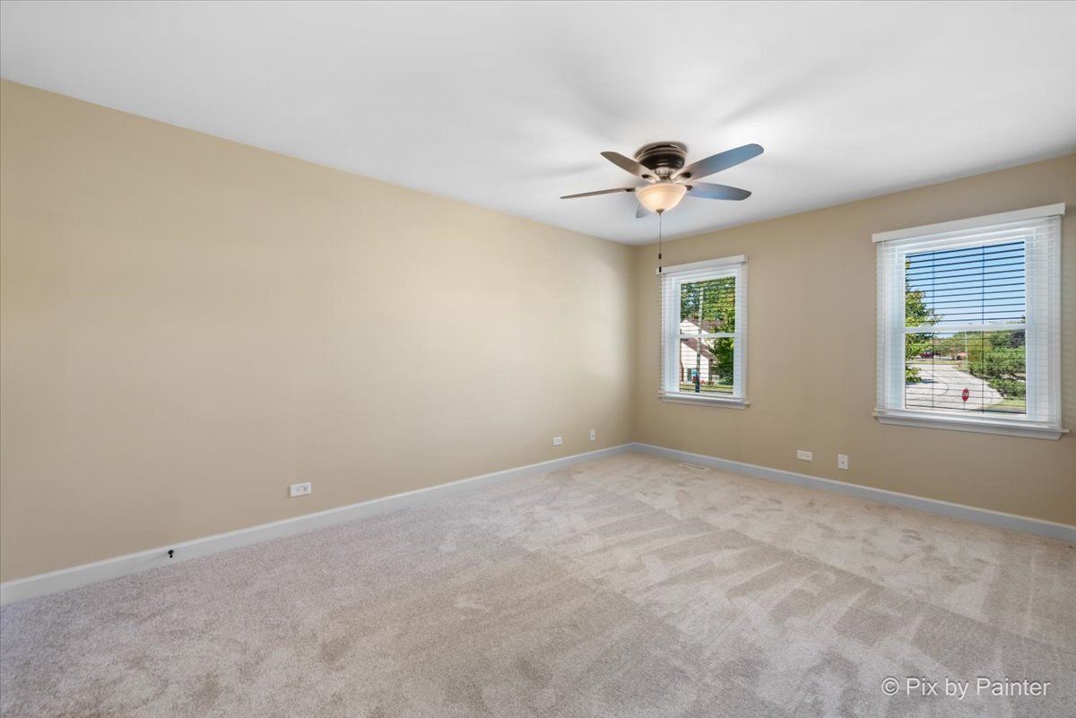 11727 Davey Drive, Unit B Huntley, IL 60142 - Photo 11 of 25 an empty room with windows and chandelier fan