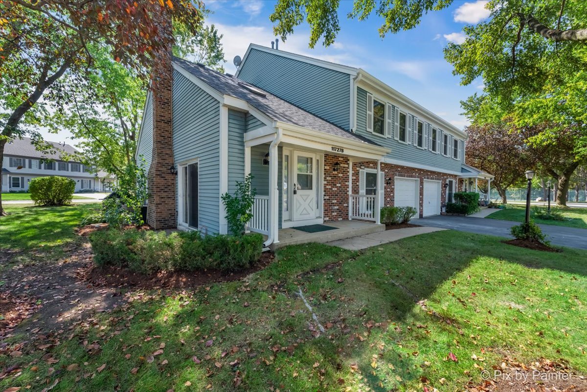 11727 Davey Drive, Unit B Huntley, IL 60142 - Photo 22 of 25 a front view of a house with a yard and potted plants