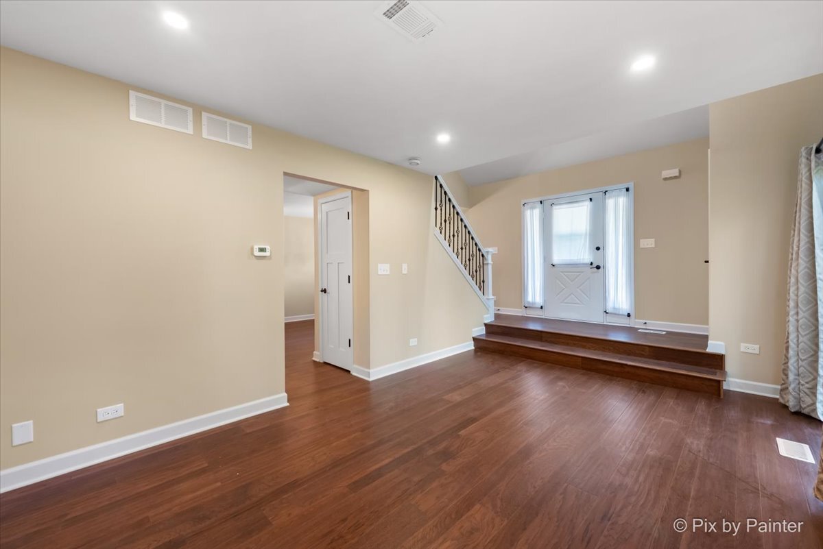 11727 Davey Drive, Unit B Huntley, IL 60142 - Photo 4 of 25 an empty room with wooden floor and windows