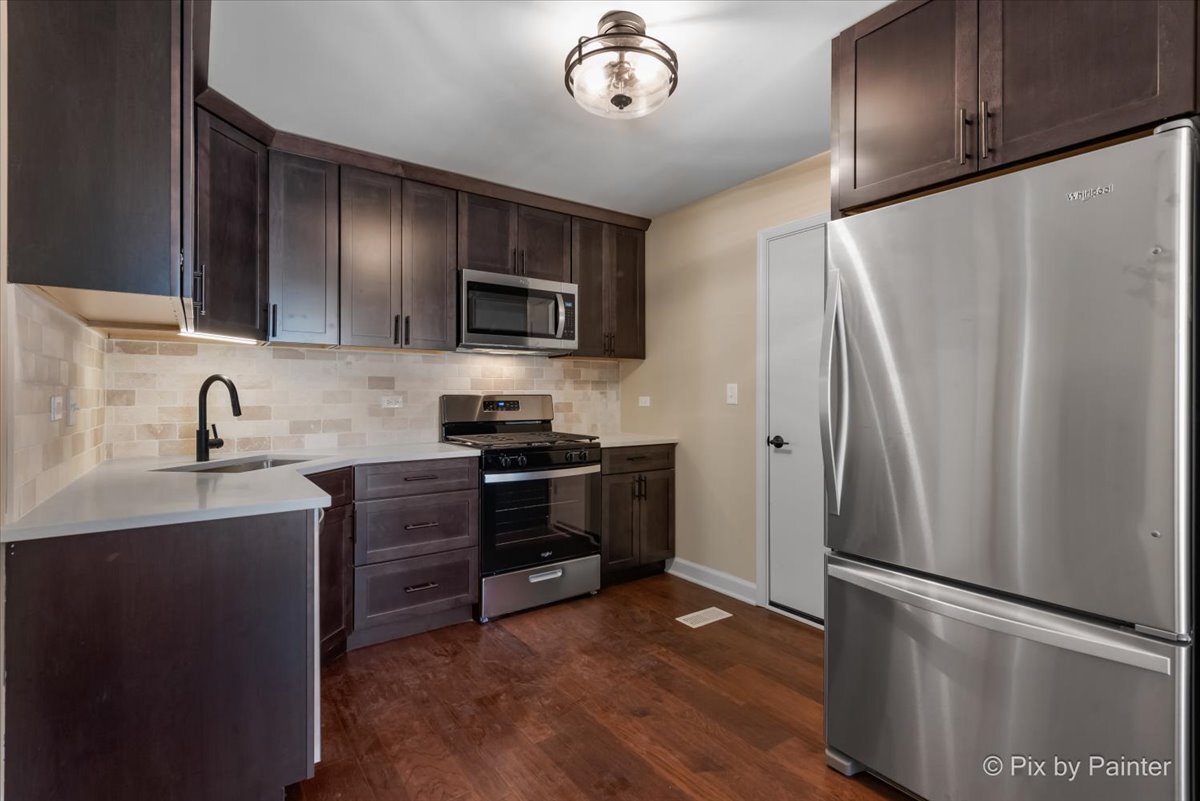 11727 Davey Drive, Unit B Huntley, IL 60142 - Photo 8 of 25 a kitchen with stainless steel appliances a refrigerator stove and sink