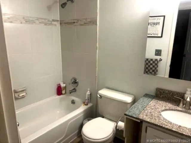 a white toilet sitting next to a bathroom sink and tub