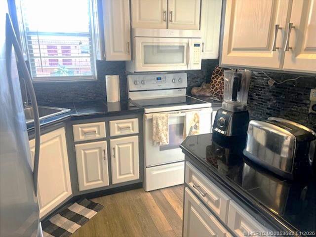 1943 Southwest Palm City Road, Unit 22F Stuart, FL 34994 - Photo 3 of 21 a kitchen with stainless steel appliances granite countertop a sink stove and cabinets