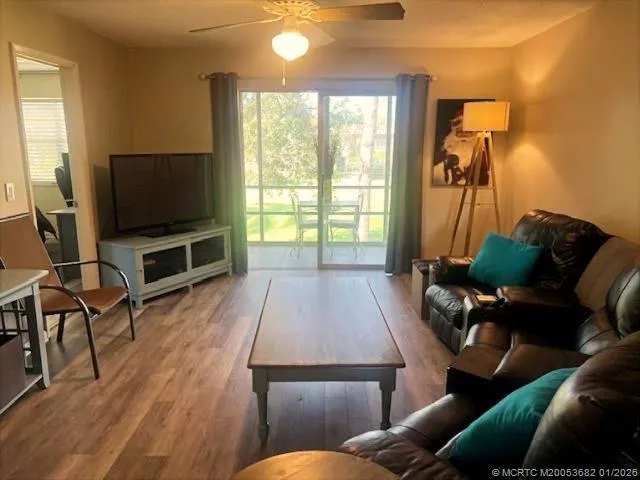 a living room with furniture a flat screen tv and a floor to ceiling window