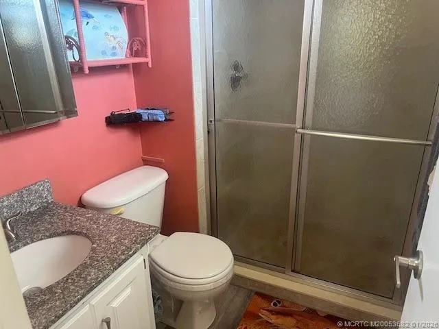 a bathroom with a granite countertop sink toilet and shower
