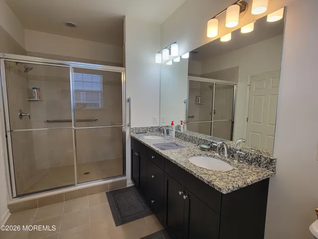 a bathroom with a granite countertop sink a shower and a mirror