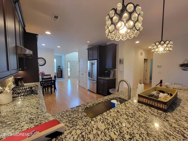 a living room with furniture a chandelier and a dining table