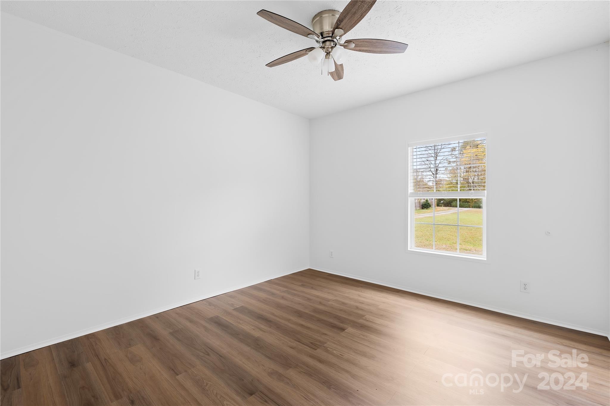 2476 Cimarron Circle Midland, NC 28107 - Photo 19 of 34 an empty room with a window and a ceiling fan