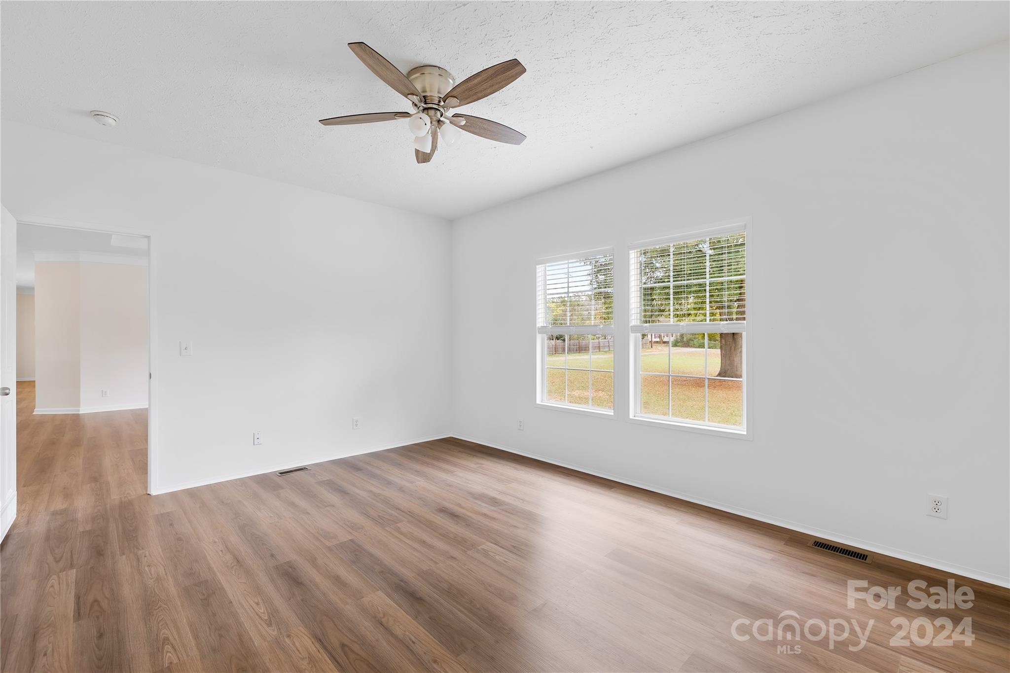 2476 Cimarron Circle Midland, NC 28107 - Photo 22 of 34 an empty room with wooden floor chandelier and windows