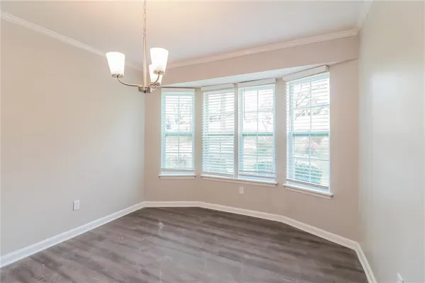 an empty room with wooden floor windows and ceiling fan