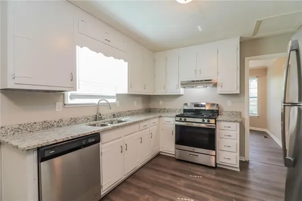 a kitchen with stainless steel appliances granite countertop a sink stove and refrigerator