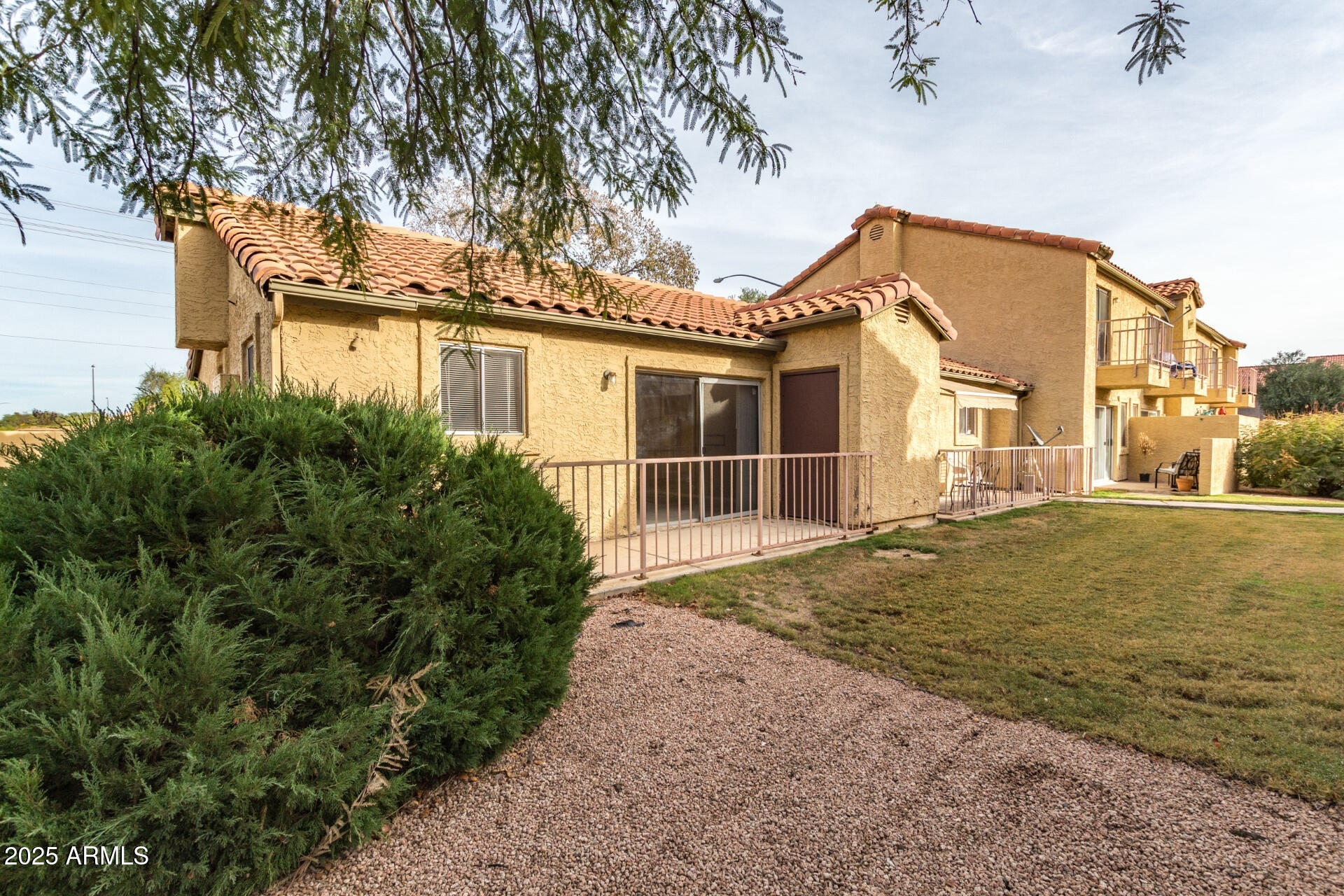 653 West Guadalupe Road, Unit 1121 Mesa, AZ 85210 - Photo 18 of 27 a view of a house with a small yard and large tree