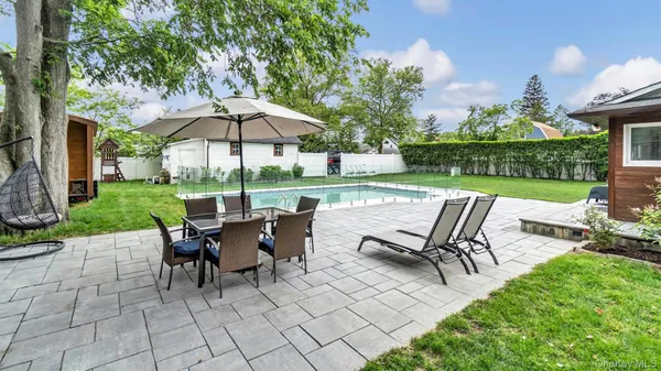a view of a patio with a table chairs and a yard