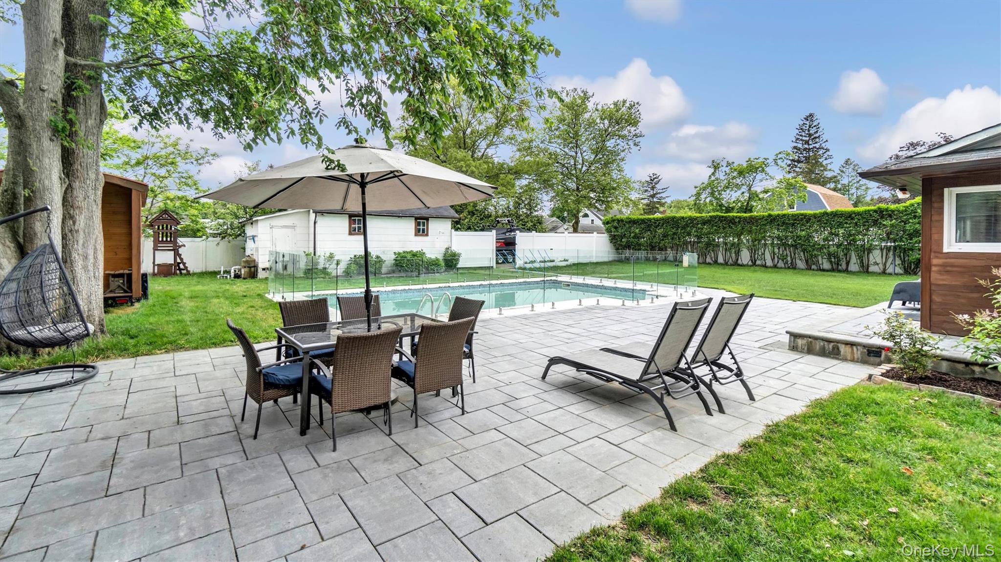 a view of a patio with a table chairs and a yard