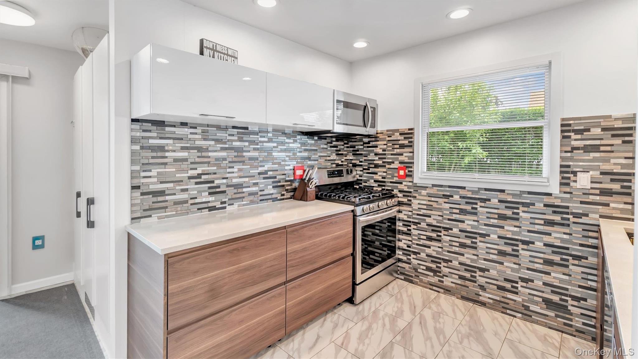143 Hallock Street Riverhead, NY 11901 - Photo 15 of 39 a kitchen with a stove and a window