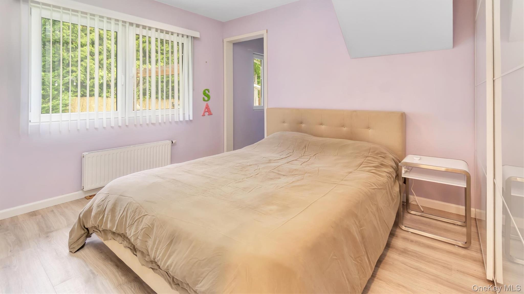 143 Hallock Street Riverhead, NY 11901 - Photo 22 of 39 a large bed sitting in a bedroom next to a window