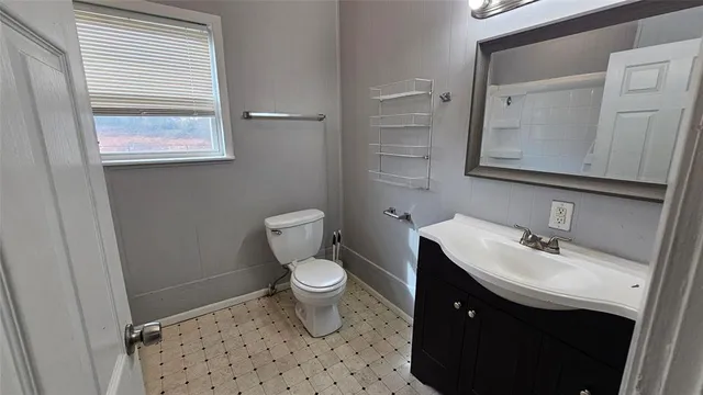 a bathroom with a sink a toilet and mirror