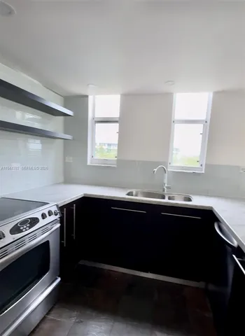 a kitchen with a sink stove and microwave