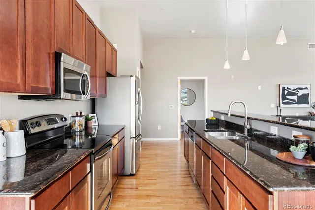 a kitchen with granite countertop a sink stove and cabinets