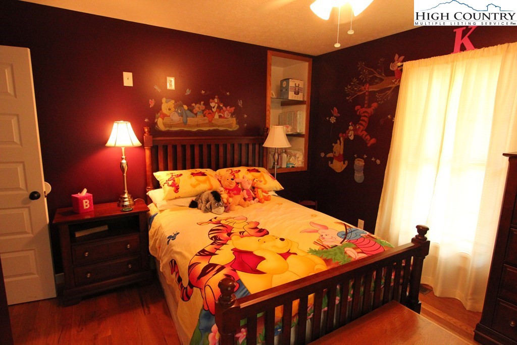 931 Graystone Road Independence, VA 24348 - Photo 19 of 32 a bed sitting in a bedroom next to a window