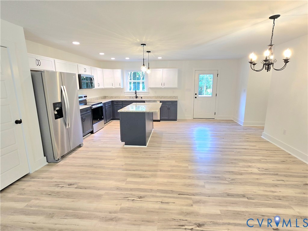 1737 Bumpass Road Bumpass, VA 23024 - Photo 15 of 26 a view of a kitchen with granite countertop a refrigerator a stove a sink dishwasher with wooden floor and cabinets