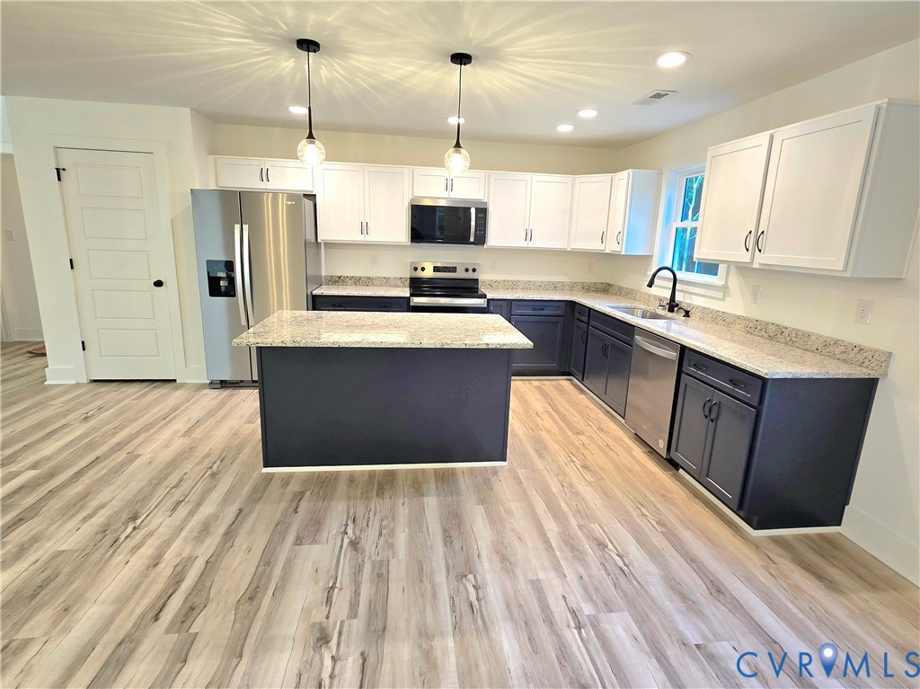 1737 Bumpass Road Bumpass, VA 23024 - Photo 17 of 26 a large kitchen with granite countertop a stove top oven a sink dishwasher and a refrigerator with wooden floor