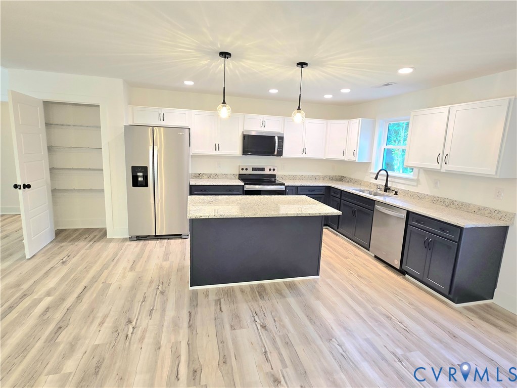 1737 Bumpass Road Bumpass, VA 23024 - Photo 18 of 26 a large kitchen with stainless steel appliances kitchen island granite countertop a stove a refrigerator a sink dishwasher with wooden cabinets and floor