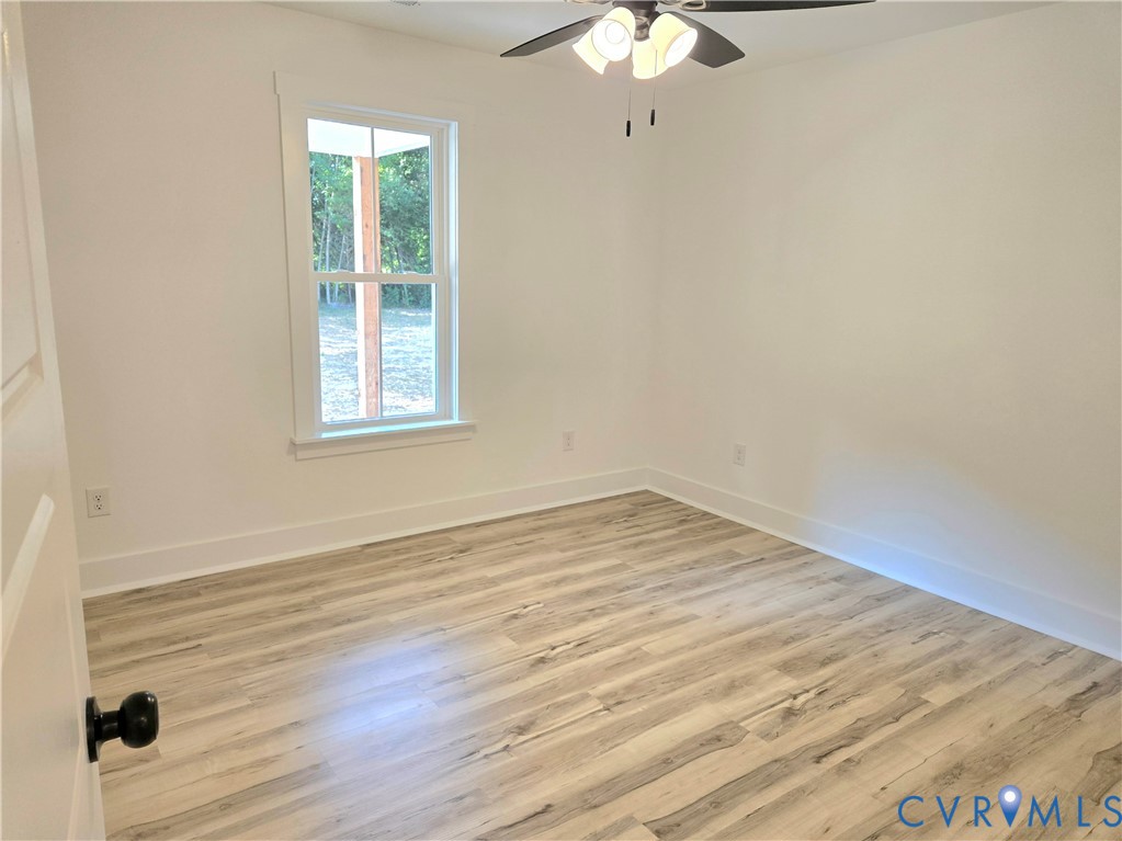 1737 Bumpass Road Bumpass, VA 23024 - Photo 19 of 26 an empty room with wooden floor fan and window