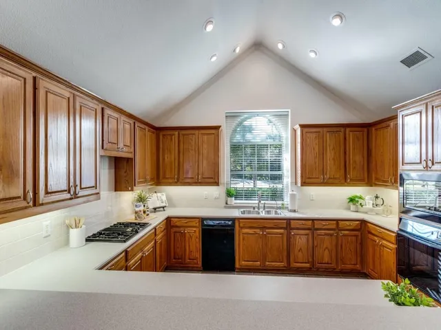 a kitchen with a sink a window and cabinets