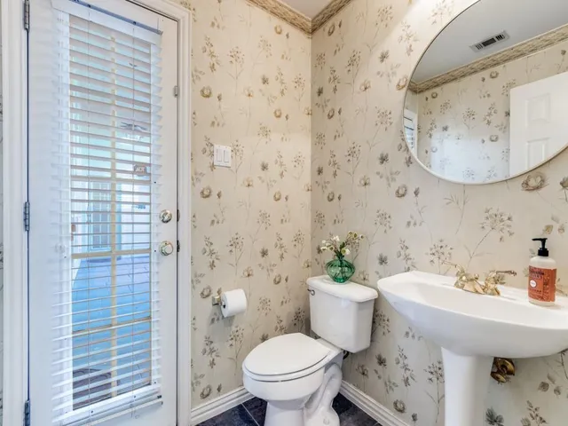 a bathroom with a sink a toilet and a mirror