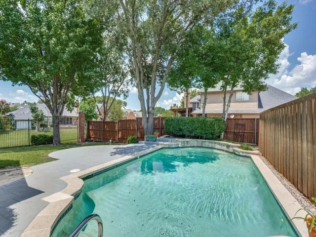 a view of backyard with a garden and trees
