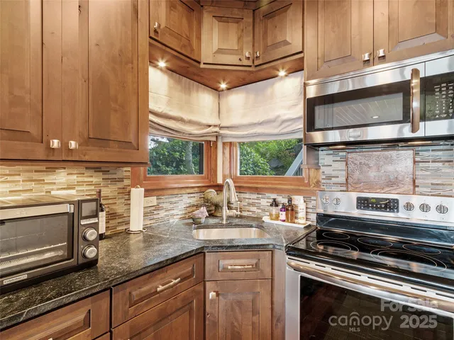 a kitchen with stainless steel appliances granite countertop a stove and a microwave