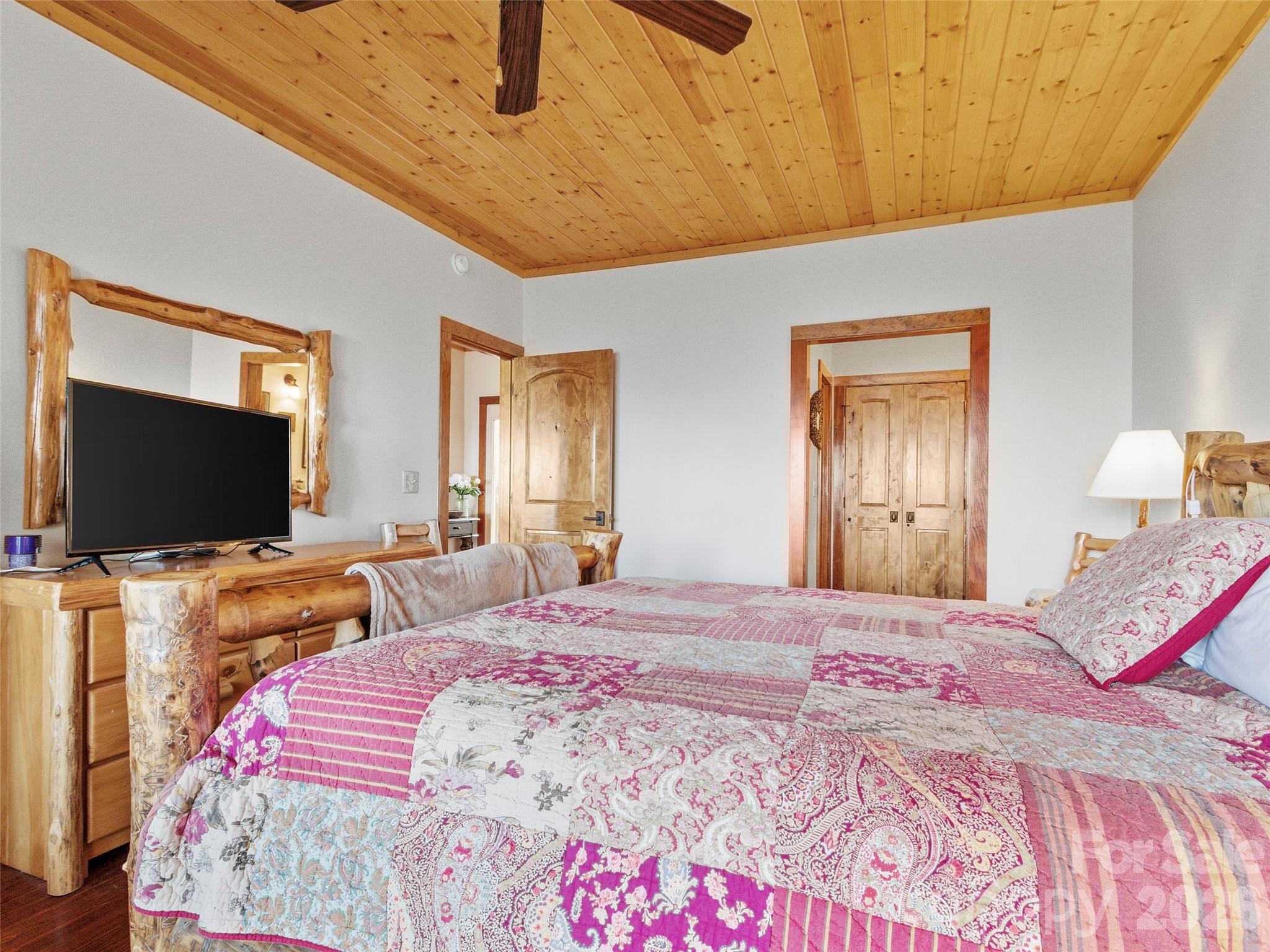 80 Slickrock Road, Unit A4 Burnsville, NC 28714 - Photo 25 of 30 a bedroom with a bed and a flat screen tv