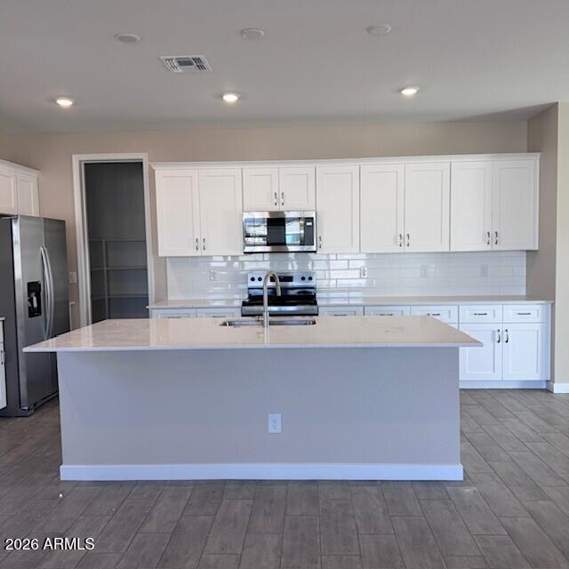 24194 West Atlantis Way Buckeye, AZ 85326 - Photo 2 of 9 a kitchen with kitchen island a counter top space stainless steel appliances and cabinets