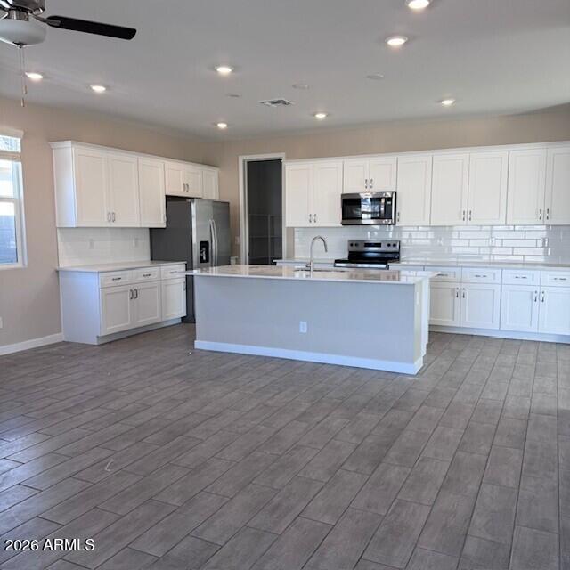24194 West Atlantis Way Buckeye, AZ 85326 - Photo 3 of 9 a large kitchen with a large counter top a sink stainless steel appliances and cabinets