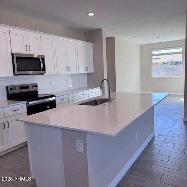 24194 West Atlantis Way Buckeye, AZ 85326 - Photo 4 of 9 a kitchen with stainless steel appliances a sink a stove a microwave a sink a refrigerator and cabinets
