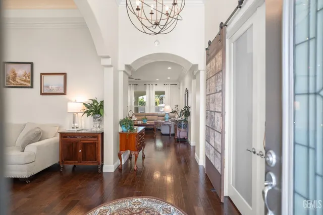 a living room with furniture a chandelier and a large mirror