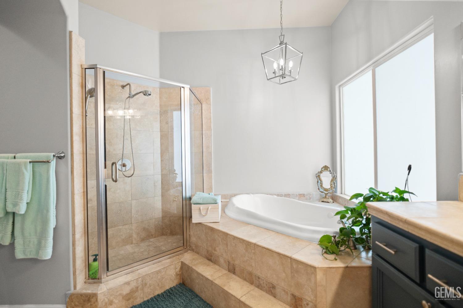 Undisclosed Address Bakersfield, CA 93311 - Photo 28 of 53 a bathroom with a granite countertop sink a mirror and a bathtub