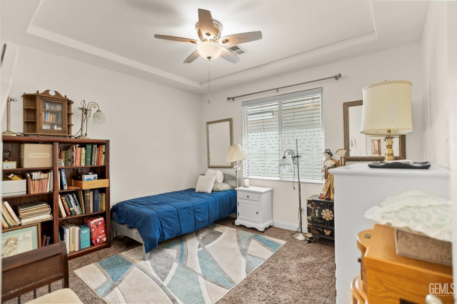 Undisclosed Address Bakersfield, CA 93311 - Photo 32 of 53 a spacious bedroom with a bed a book shelf and a window