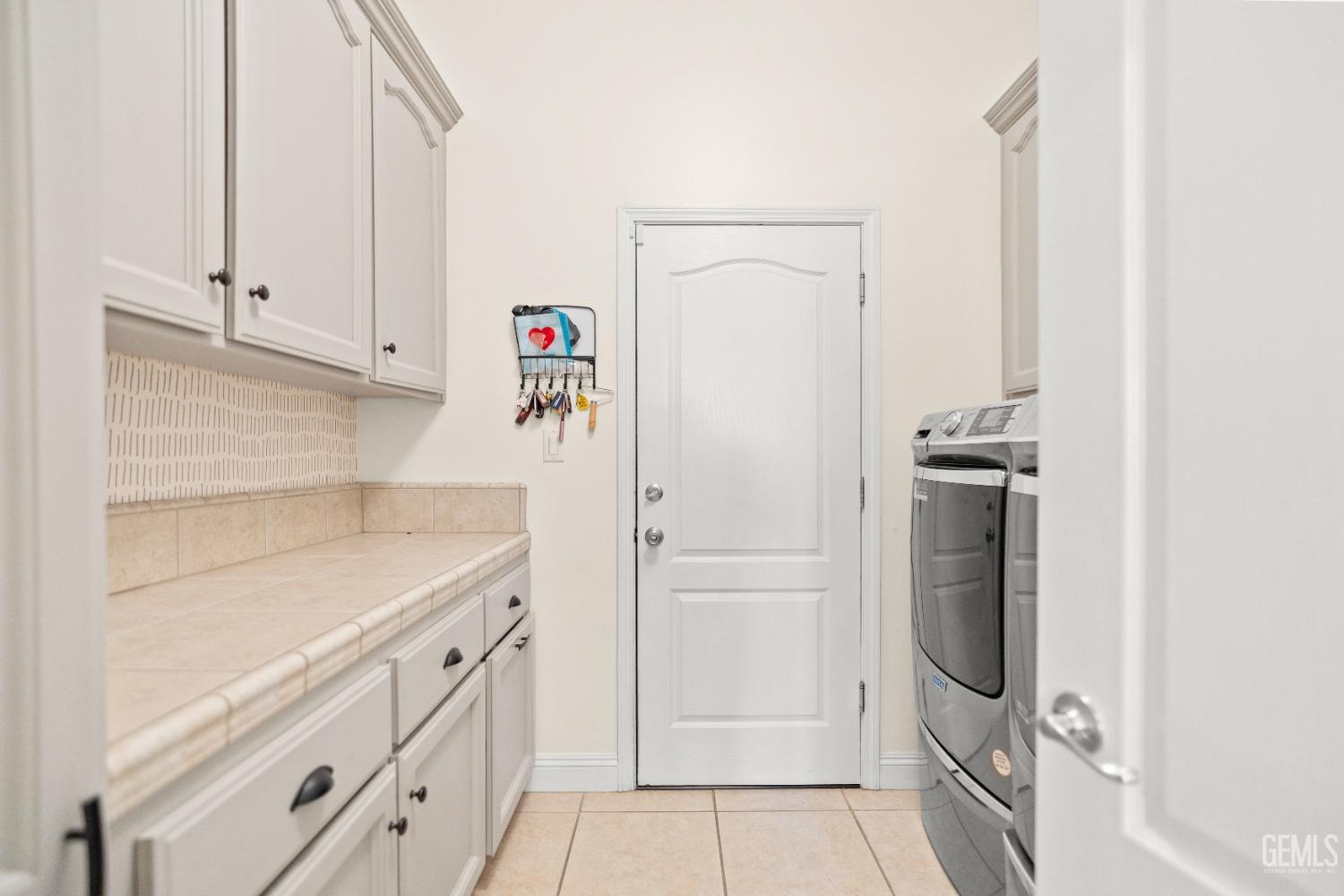 Undisclosed Address Bakersfield, CA 93311 - Photo 36 of 53 a utility room with cabinets washer and dryer