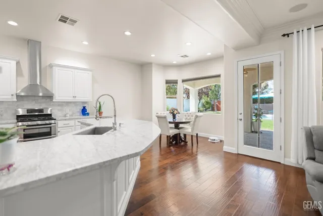 a large white kitchen with lots of counter space wooden floor and appliances