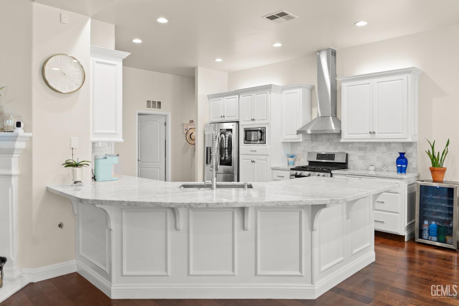 Undisclosed Address Bakersfield, CA 93311 - Photo 10 of 53 a large white kitchen with lots of counter space wooden floor and appliances
