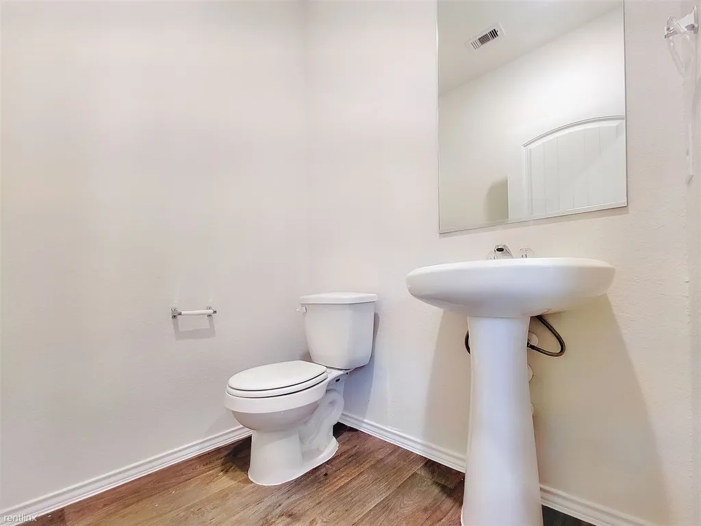 419 Sickle Loop Kyle, TX 78640 - Photo 13 of 35 Functional design with a pedestal sink and toilet, offering convenience in a compact space.