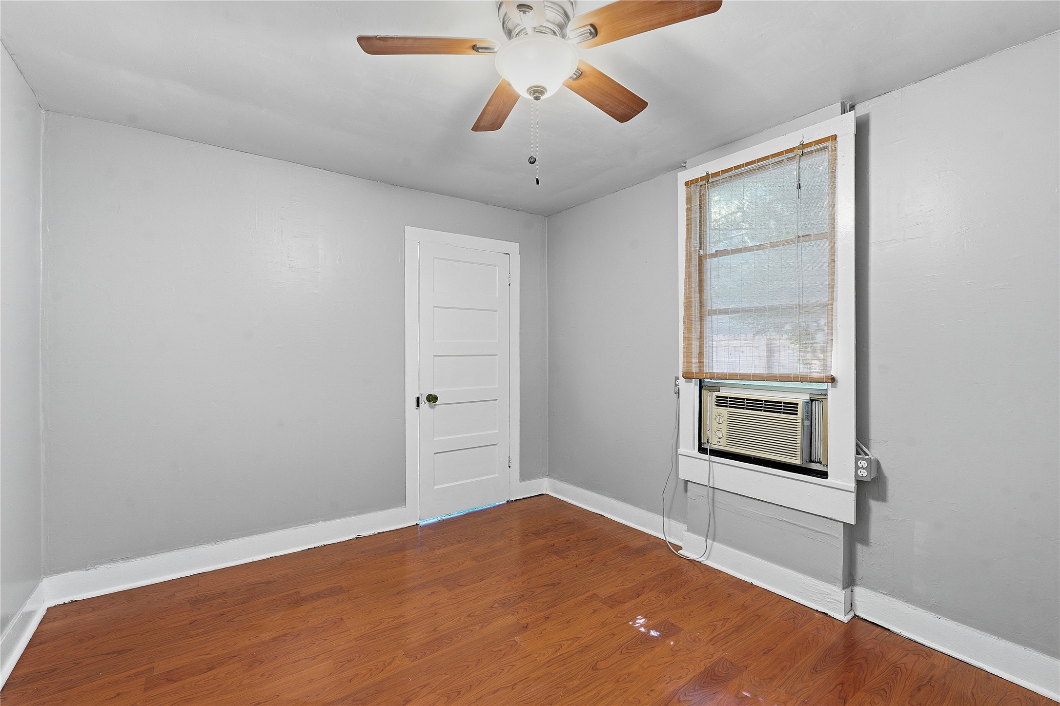 2207 Santa Rita Street Austin, TX 78702 - Photo 9 of 15 Room featuring wood-finish flooring, light grey walls, and white trim