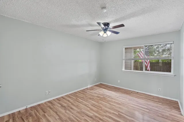 wooden floor in an empty room with a bathroom